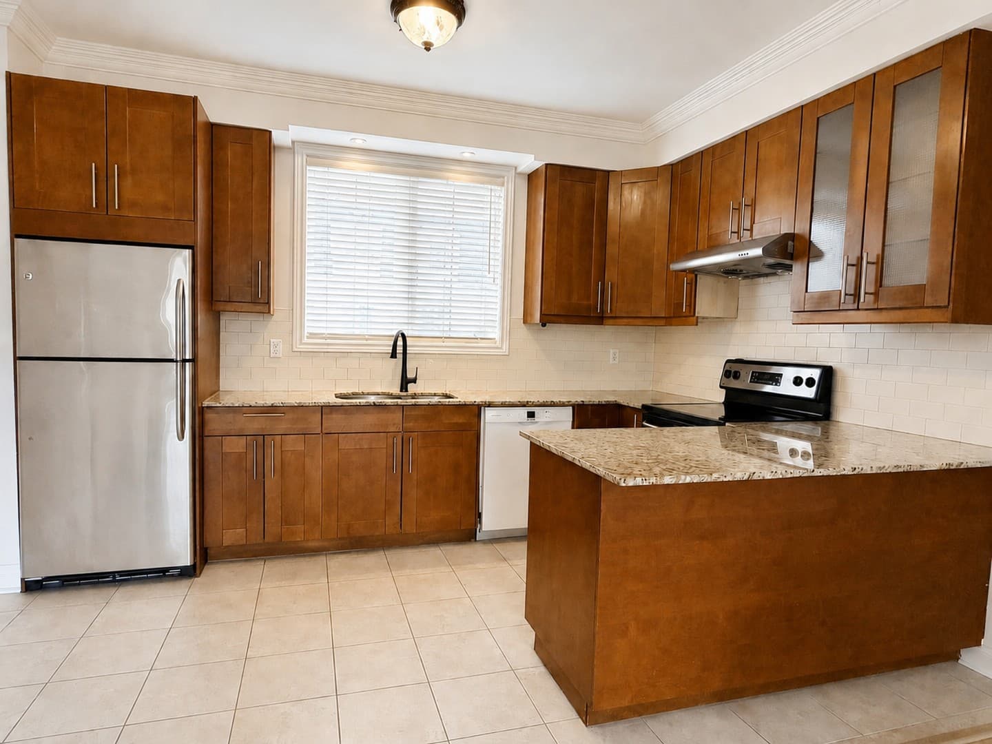 Overview of empty kitchen island and refrigerator area